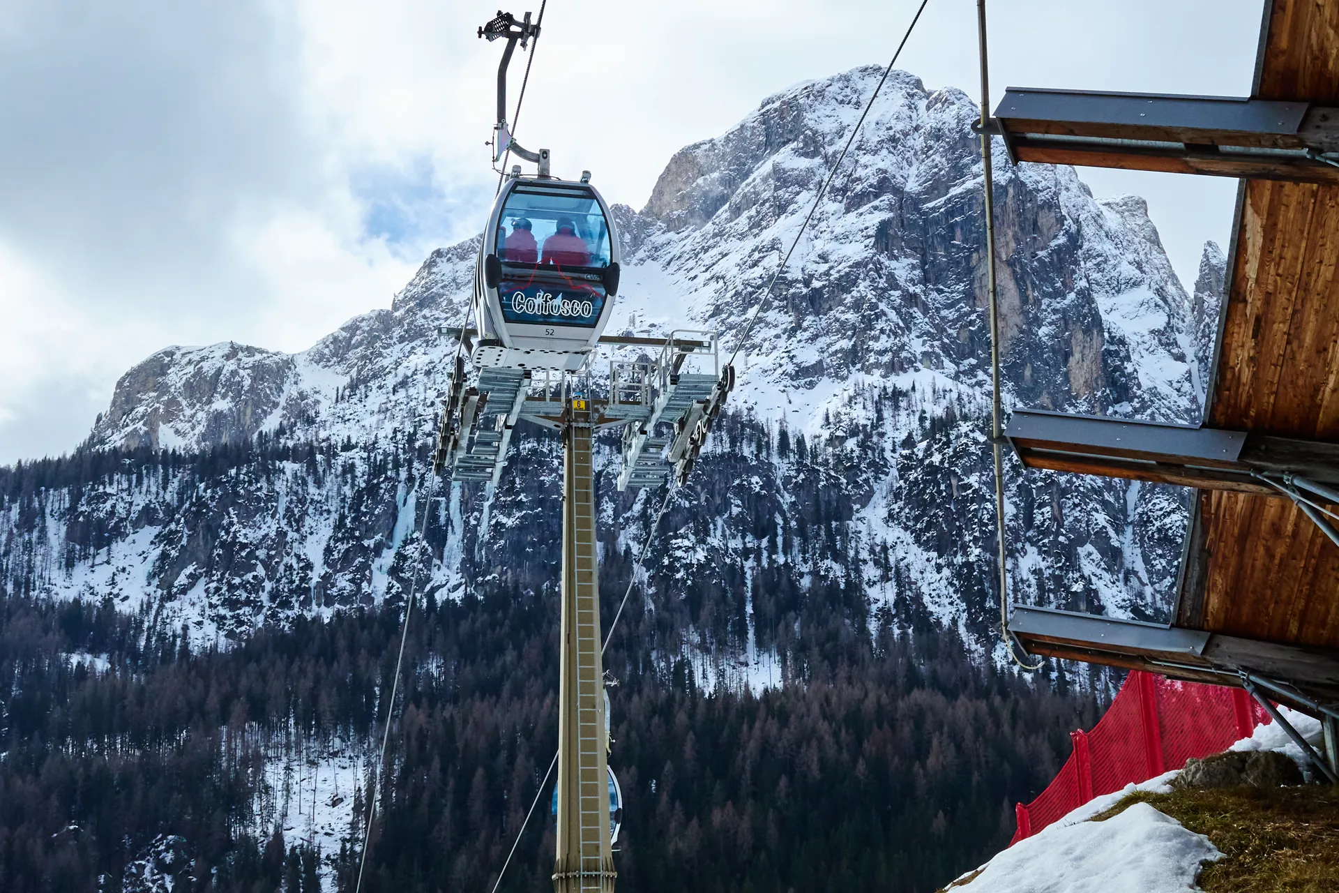 Ai piedi del gruppo del Sella, gli impianti di risalita spostano turisti e sciatori tra lingue di neve tecnica e prati verdi