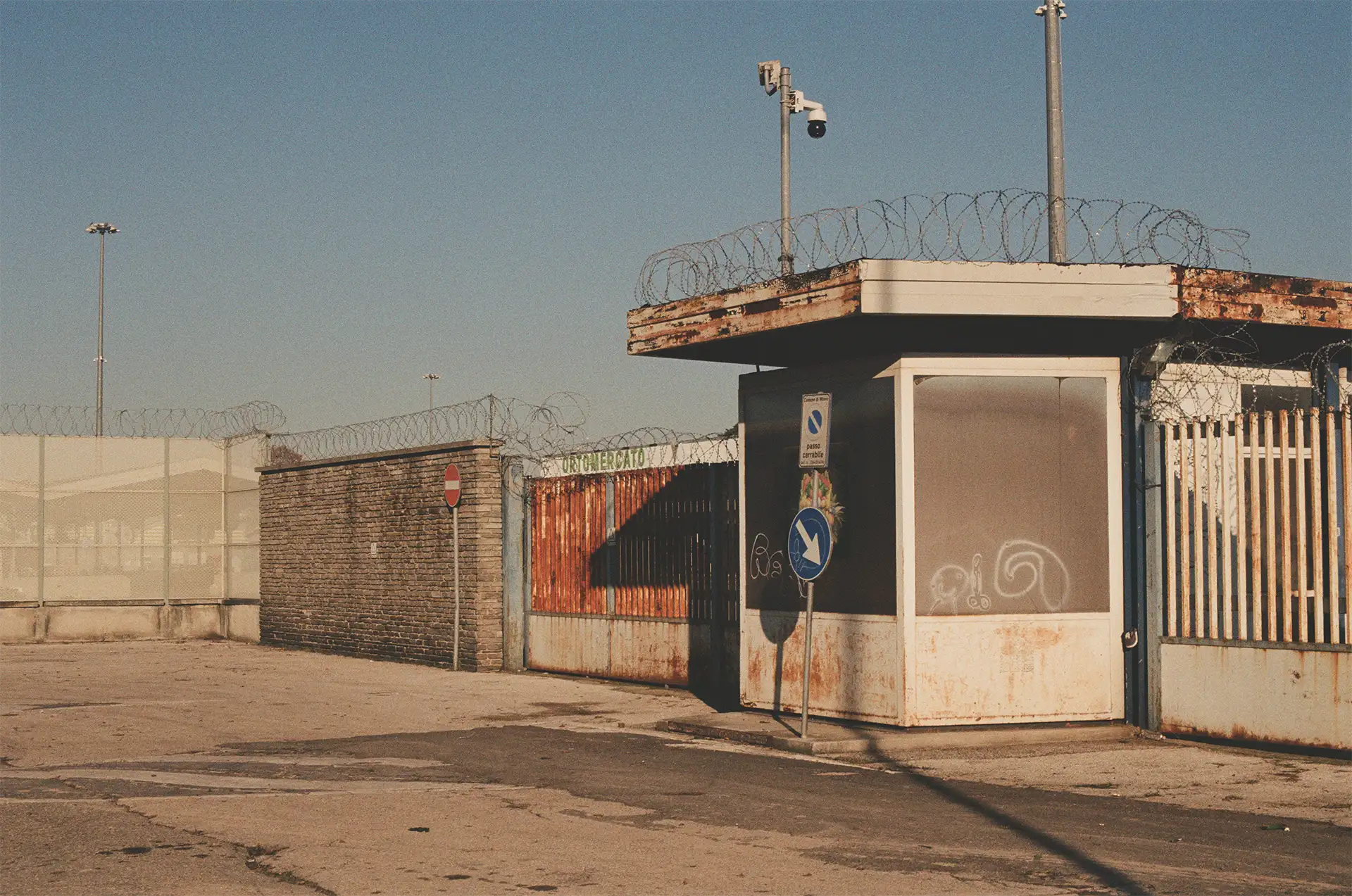 Una delle entrate dell’ortomercato, “militarizzate” con filo spinato e videocamere, su via Varsavia