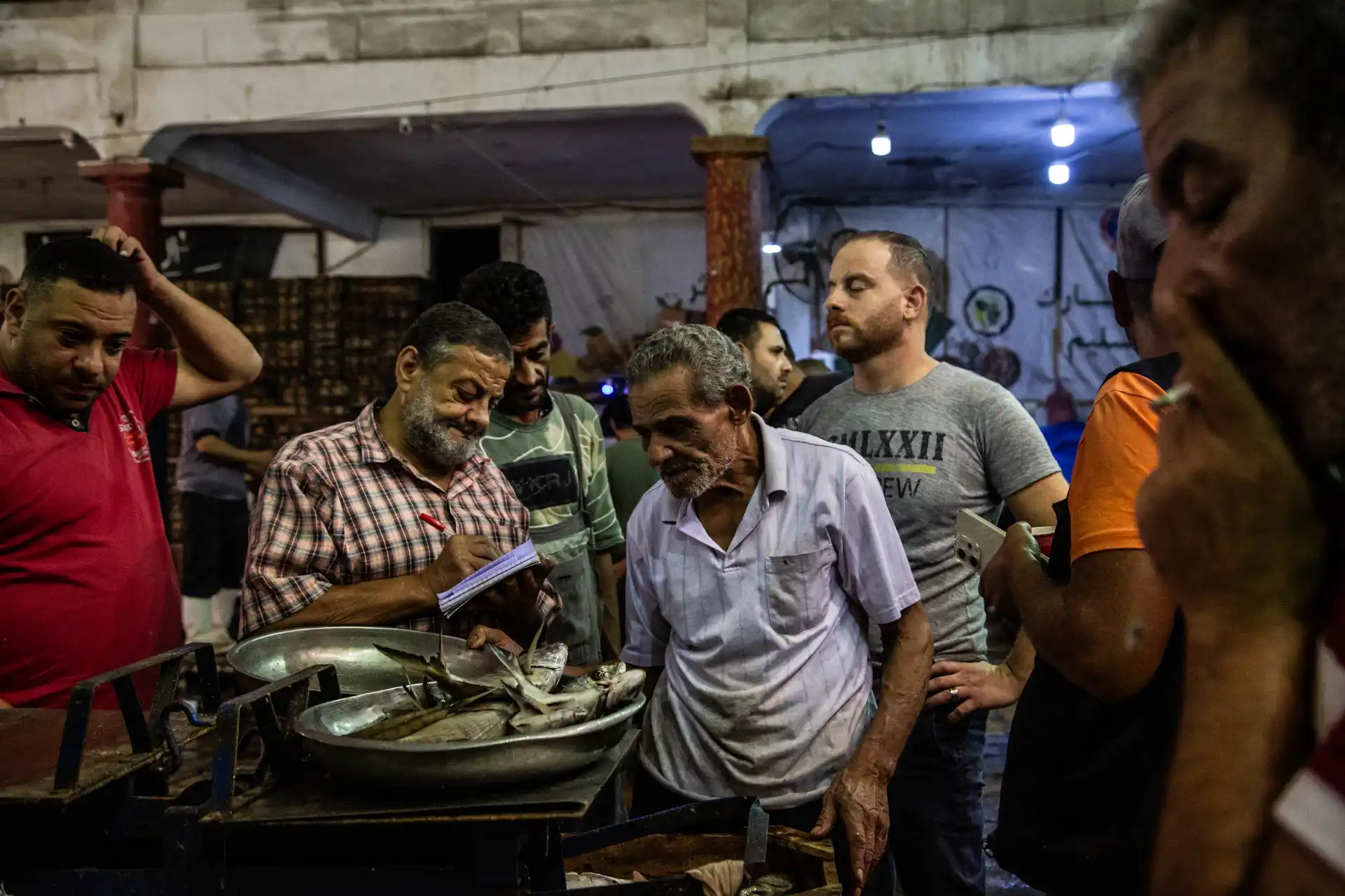 Alessandria d'Egitto - Pescatori e acquirenti durante la contrattazione. Mercato del pesce Halaqet El Samak, quartiere Anfushi.