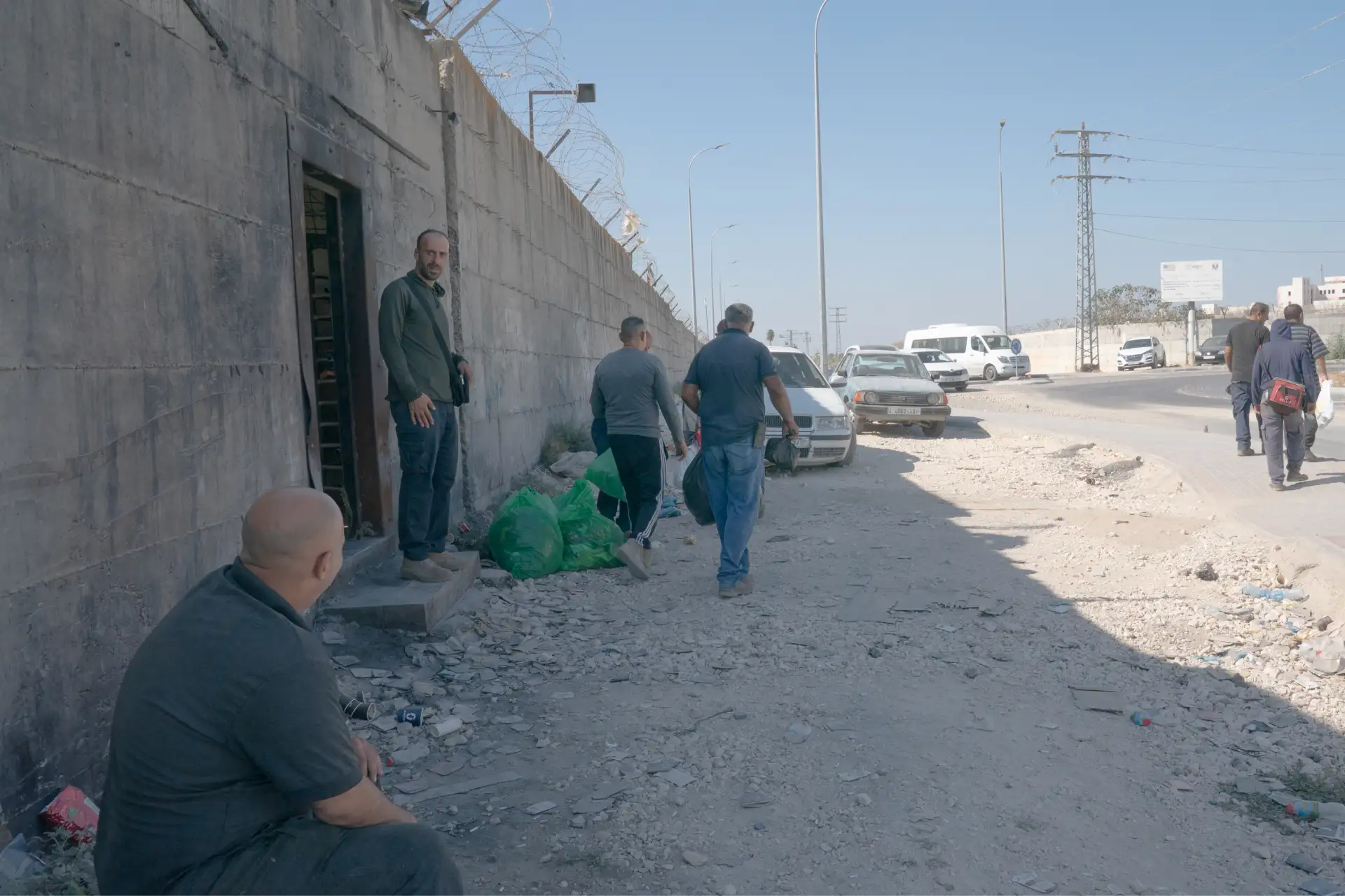 I lavoratori palestinesi escono dal complesso industriale di Nitzanei Shalom al termine del loro turno. Passano attraverso un piccolo cancello incastonato nel muro orientale - l’unico punto di ingresso e di uscita per i lavoratori palestinesi - sorvegliato da guardie di sicurezza private israeliane, armate