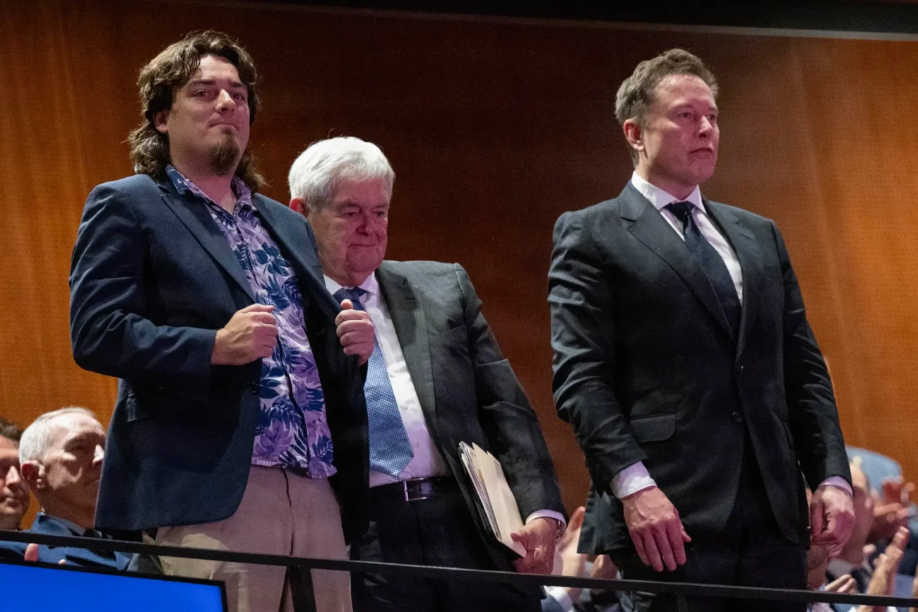Da sinistra, Palmer Luckey, Newt Gingrich ed Elon Musk in piedi durante il discorso del Segretario alla Guerra Pete Hegseth rivolto agli ufficiali subalterni e ai capi di reparto durante il discorso sullo “Stato delle Forze Armate” tenuto presso la base del Corpo dei Marines di Quantico, in Virginia, il 30 settembre 2026